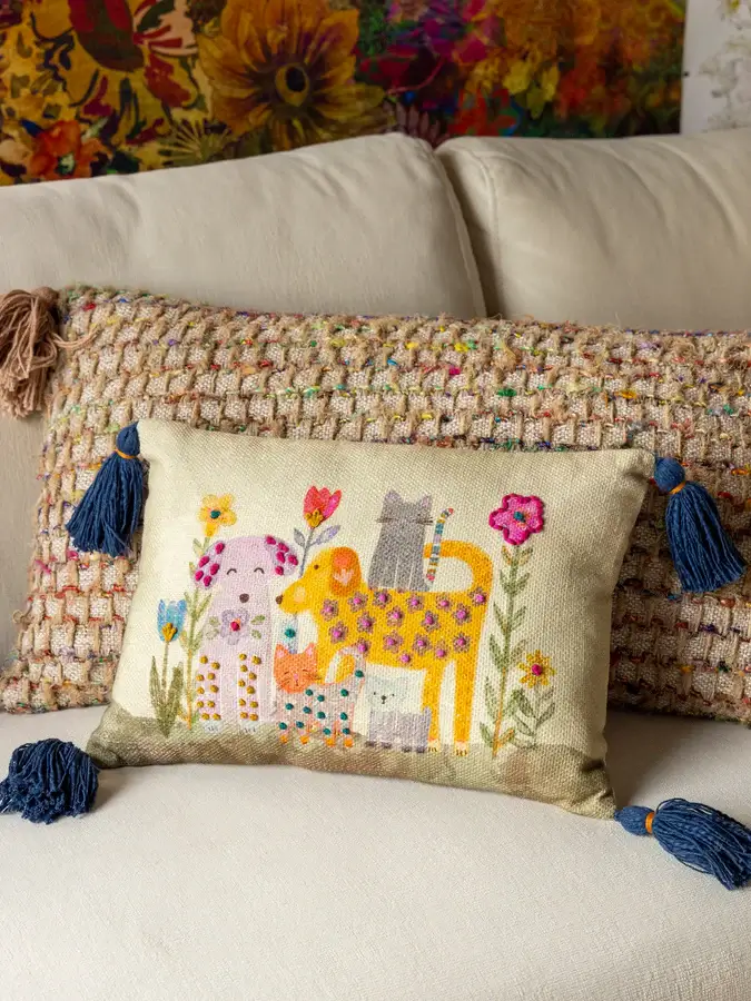 Almohada crema de animalitos con borlas